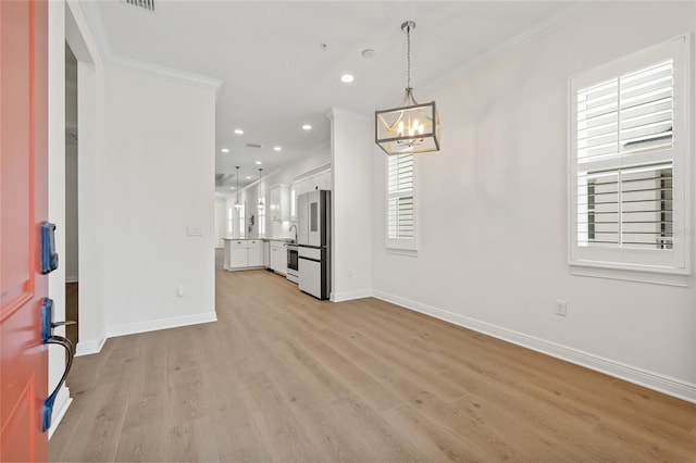 interior space featuring light hardwood / wood-style flooring, crown molding, and a notable chandelier