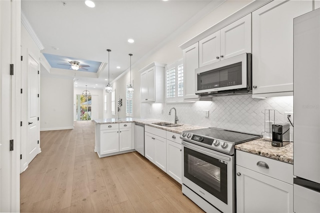 kitchen with white cabinetry, hanging light fixtures, appliances with stainless steel finishes, and kitchen peninsula