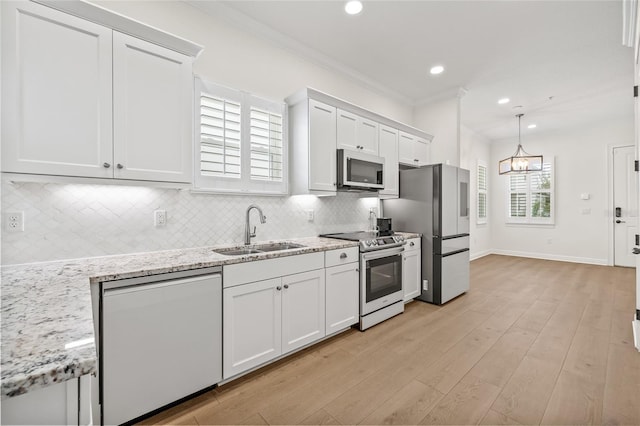 kitchen with light stone countertops, stainless steel appliances, white cabinets, and sink