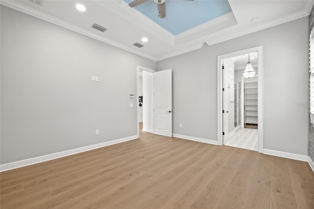 unfurnished bedroom with ceiling fan, light wood-type flooring, and ornamental molding