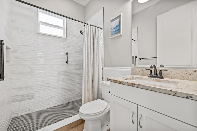 bathroom featuring toilet, walk in shower, and vanity