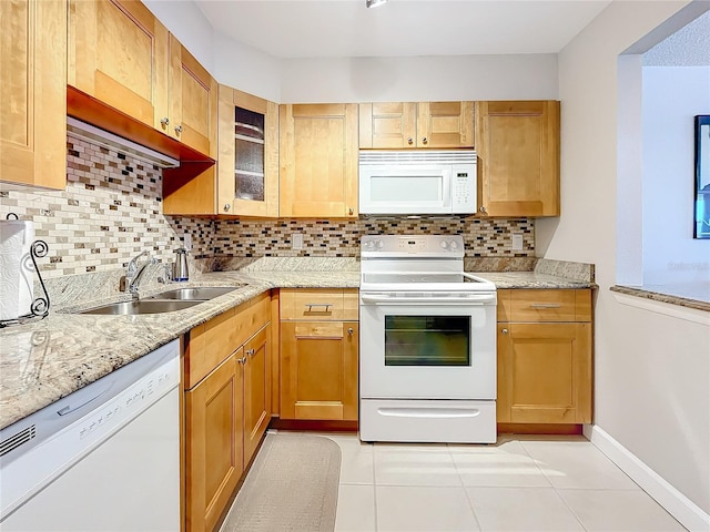 kitchen with light tile patterned flooring, sink, decorative backsplash, light stone countertops, and white appliances