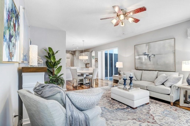 living room featuring wood-type flooring and ceiling fan