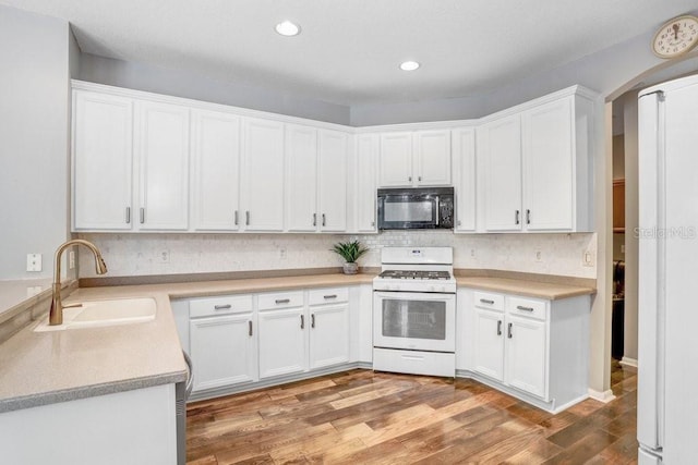 kitchen featuring hardwood / wood-style flooring, sink, white cabinets, and gas range gas stove