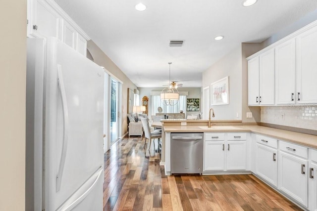 kitchen with dishwasher, white fridge, and white cabinets