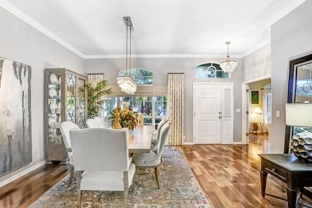 dining room with wood-type flooring, crown molding, and a chandelier