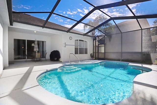 view of swimming pool featuring a patio and glass enclosure