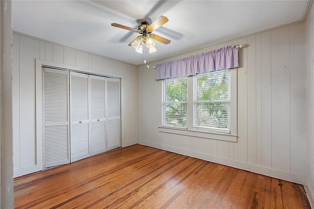 unfurnished bedroom featuring light wood-type flooring, ceiling fan, and a closet