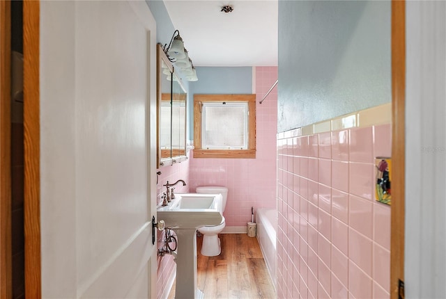 bathroom with hardwood / wood-style floors, sink, tile walls, and toilet