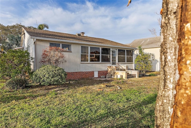 rear view of property with a yard