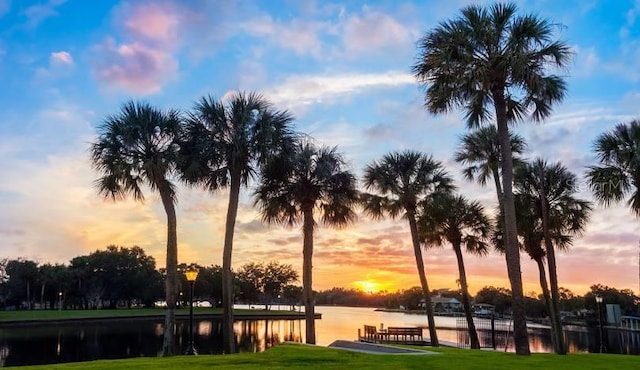 surrounding community featuring a water view and a lawn