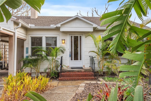 17 Venetian Ct, Tarpon Springs, FL 34689 - doorway to property with roof with shingles and a chimney