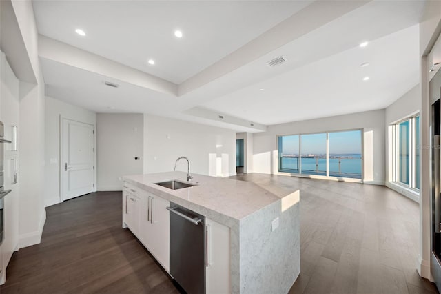 kitchen with dark wood-type flooring, sink, dishwasher, an island with sink, and white cabinets