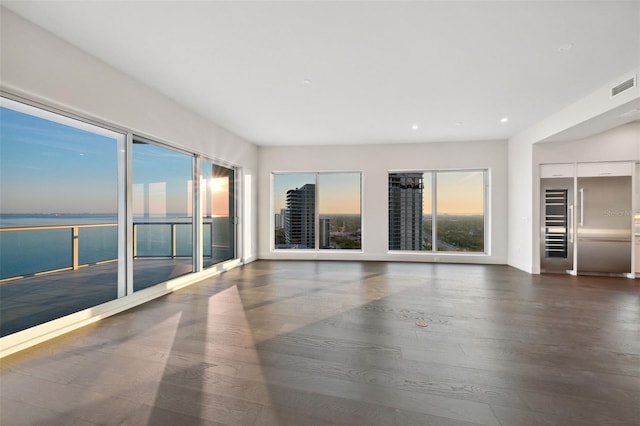 unfurnished room with elevator, visible vents, wood finished floors, and recessed lighting