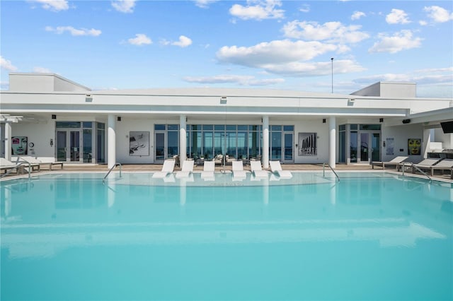 pool with french doors and a patio