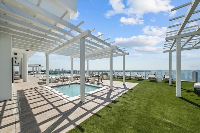 community pool featuring a water view, a patio area, a lawn, and a pergola