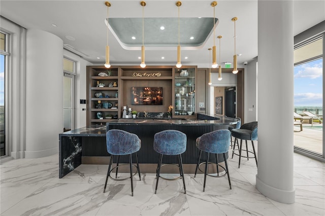 bar with recessed lighting, bar area, marble finish floor, a tray ceiling, and pendant lighting