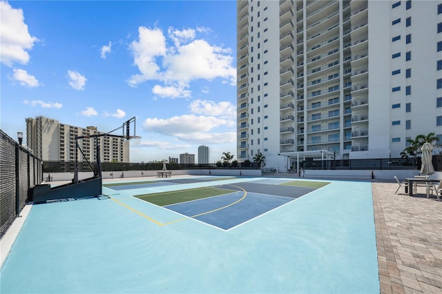 view of basketball court featuring a view of city, community basketball court, and fence