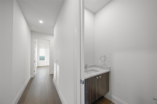 bathroom featuring recessed lighting, vanity, baseboards, and wood finished floors