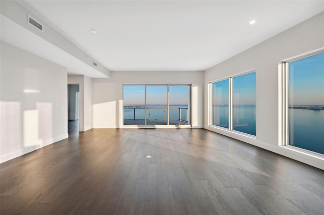 spare room with wood finished floors, baseboards, and recessed lighting