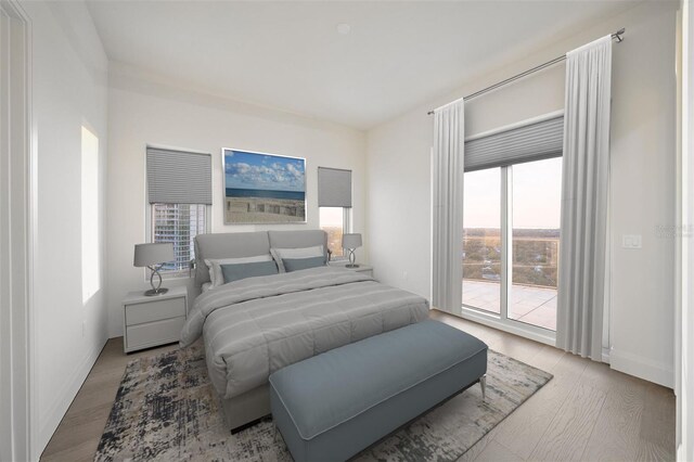 bedroom with access to outside and wood finished floors