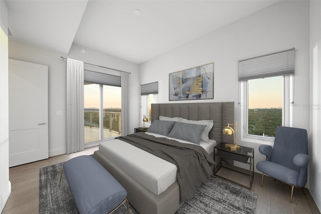 bedroom with access to exterior, wood finished floors, and baseboards