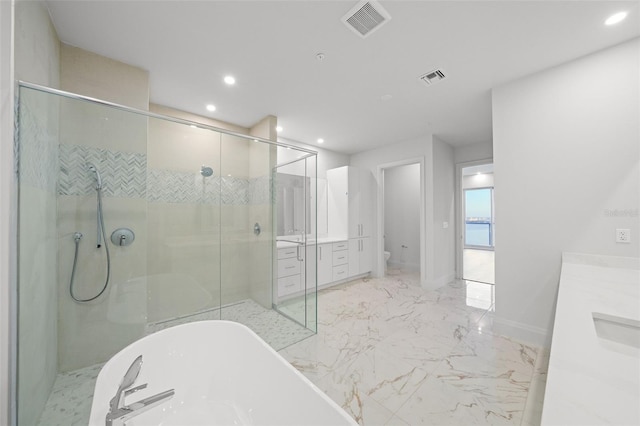 full bathroom featuring vanity, recessed lighting, a shower stall, marble tiled floors, and a freestanding bath