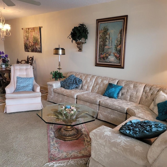 living room featuring a textured ceiling, a notable chandelier, and carpet flooring