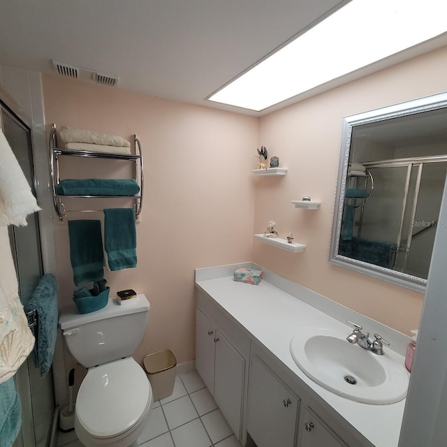 bathroom featuring tile patterned flooring, an enclosed shower, toilet, a skylight, and vanity