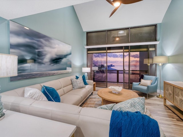 living room featuring lofted ceiling, light wood-type flooring, and ceiling fan