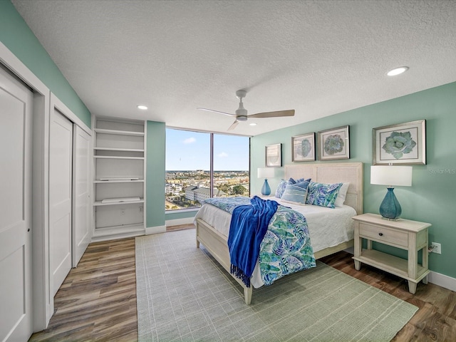 bedroom featuring a textured ceiling, ceiling fan, and wood-type flooring