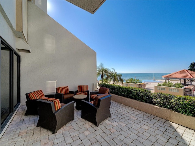 view of patio / terrace with an outdoor hangout area, a view of the beach, a gazebo, and a water view