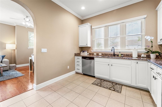 kitchen with white cabinetry, stainless steel dishwasher, light tile patterned flooring, and sink