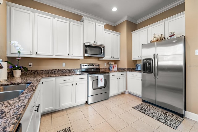 kitchen with white cabinetry, stainless steel appliances, crown molding, and light tile patterned floors