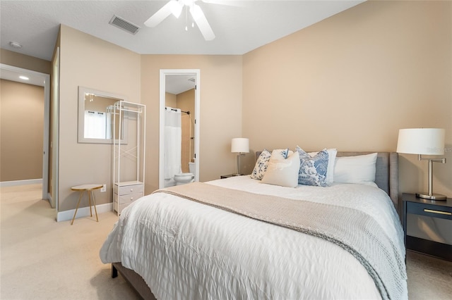 bedroom with ceiling fan, connected bathroom, and light carpet