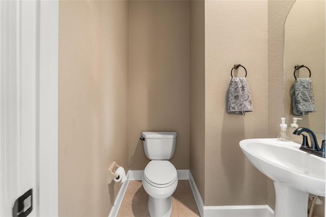 bathroom featuring tile patterned floors, toilet, and sink