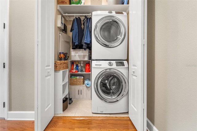 washroom featuring stacked washer / drying machine and light tile patterned floors