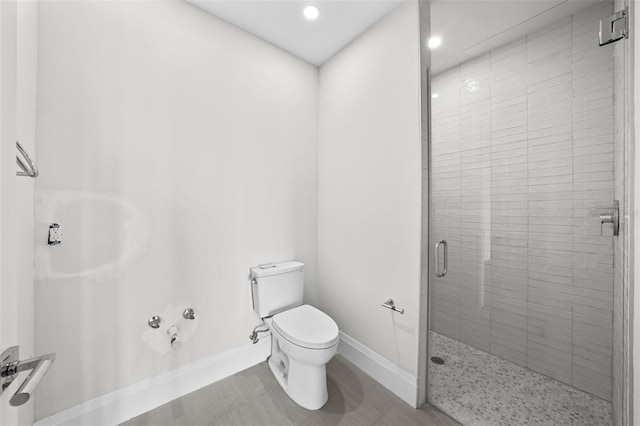 bathroom with toilet and a shower with shower door