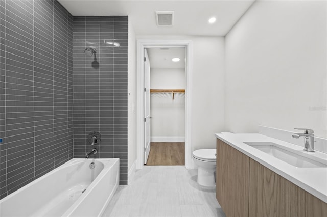 full bathroom featuring toilet, vanity, and tiled shower / bath combo