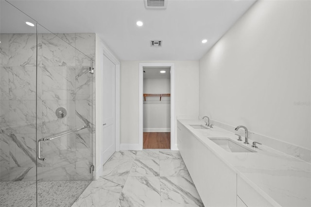 bathroom with a shower with shower door and vanity