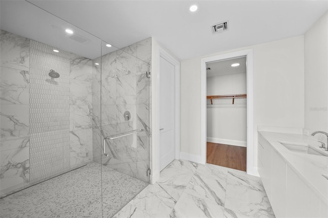 bathroom with a shower with shower door and vanity