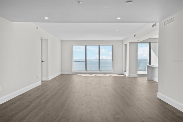 unfurnished room with a water view and hardwood / wood-style floors