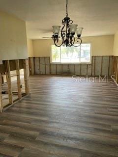 dining room featuring a healthy amount of sunlight, dark wood-type flooring, and a chandelier