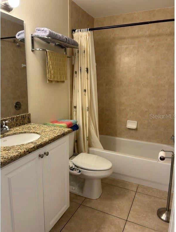 full bathroom featuring vanity, shower / bathtub combination with curtain, tile patterned floors, and toilet