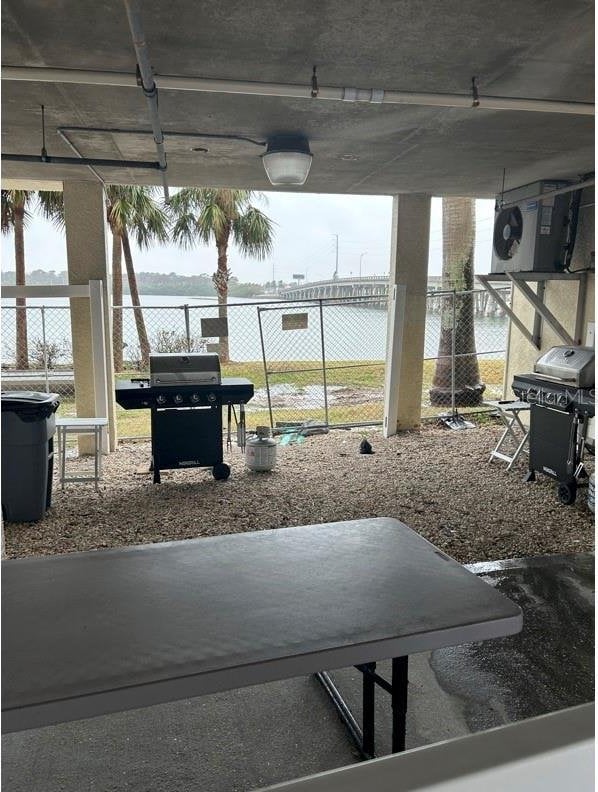 view of patio with a water view, grilling area, and a pergola