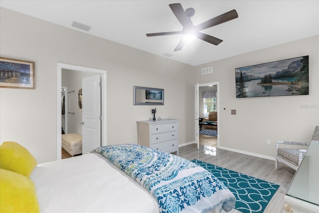 bedroom with ceiling fan, light hardwood / wood-style floors, and ensuite bath