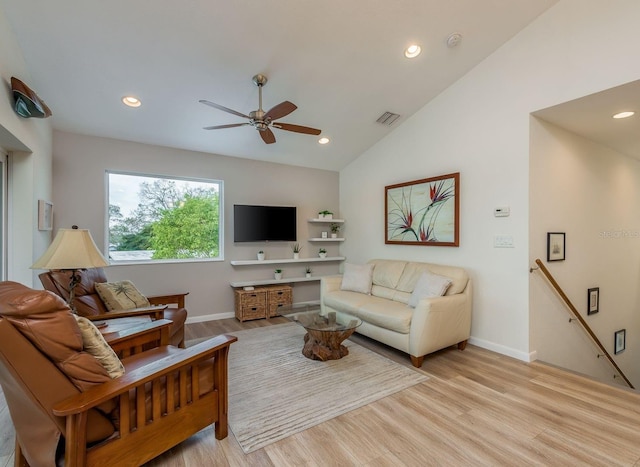 living room featuring vaulted ceiling, ceiling fan, and light wood-type flooring