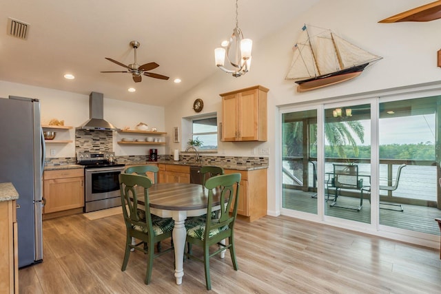 kitchen with appliances with stainless steel finishes, wall chimney range hood, light brown cabinets, and decorative backsplash