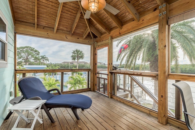 sunroom / solarium with vaulted ceiling with beams, a wealth of natural light, and ceiling fan