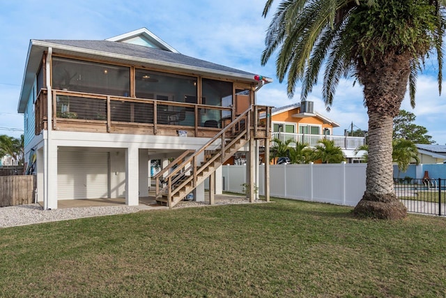 rear view of house featuring a yard, a patio, and a sunroom